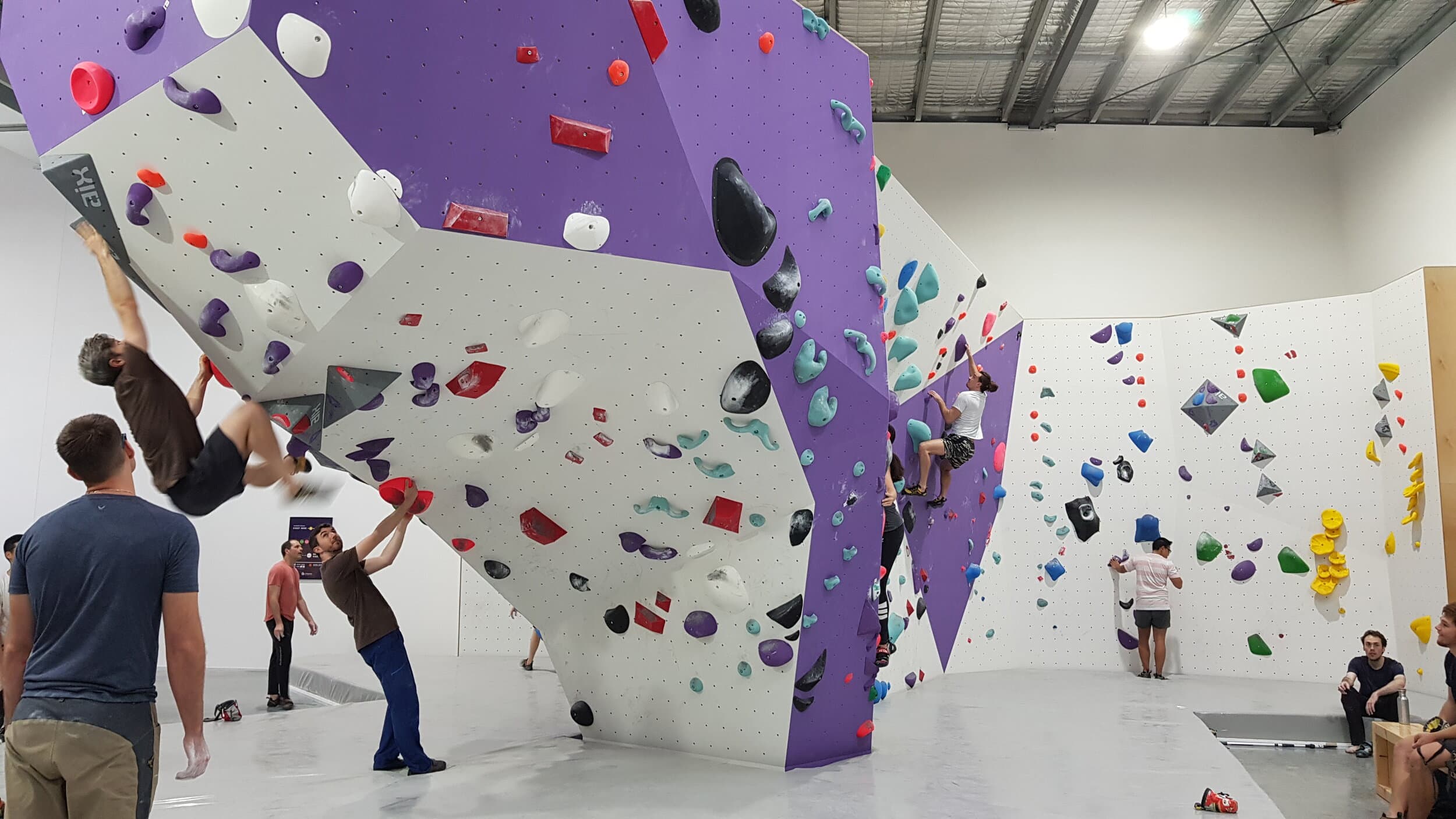 Man climbing on volumes and a red route at Lane Cove