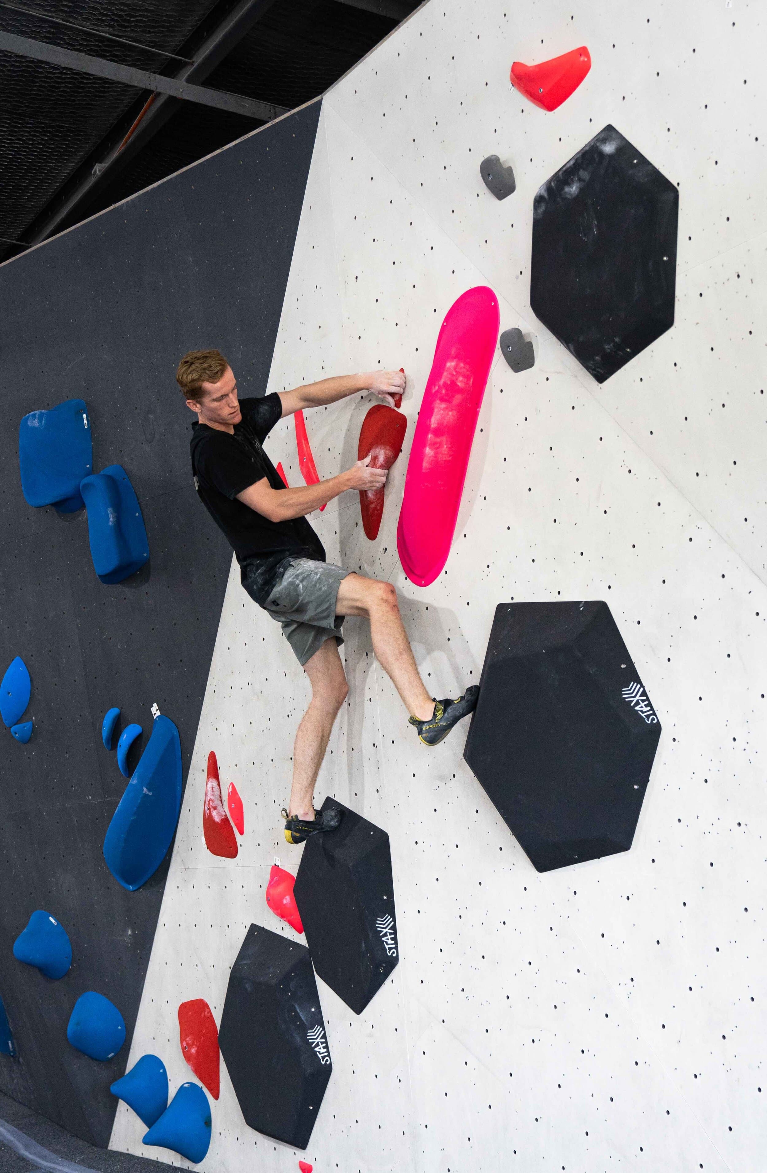 Man climbing on volumes and a red route at Lane Cove